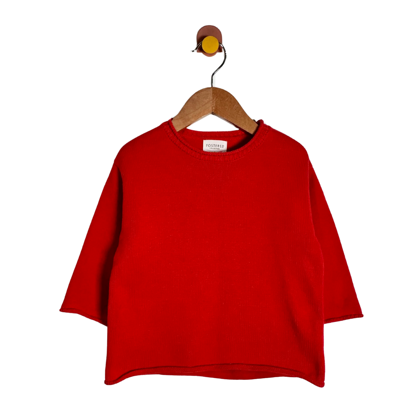 A bright red knit sweater with three-quarter sleeves, hanging on a wooden hanger against a plain white background.