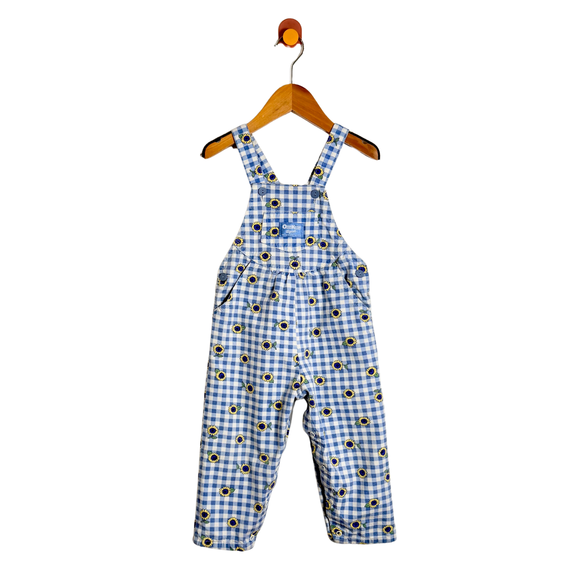 A baby's blue and white gingham overall romper with a black and yellow flower print pattern, hanging on a wooden hanger against a white background.