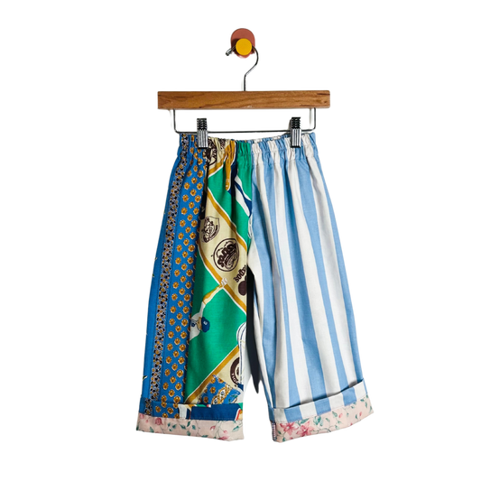 Colorful patterned pants on a hanger against a white background