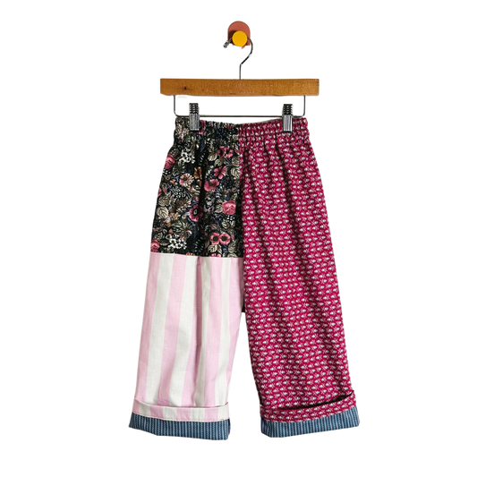 Colorful patterned pants on a hanger against a white background