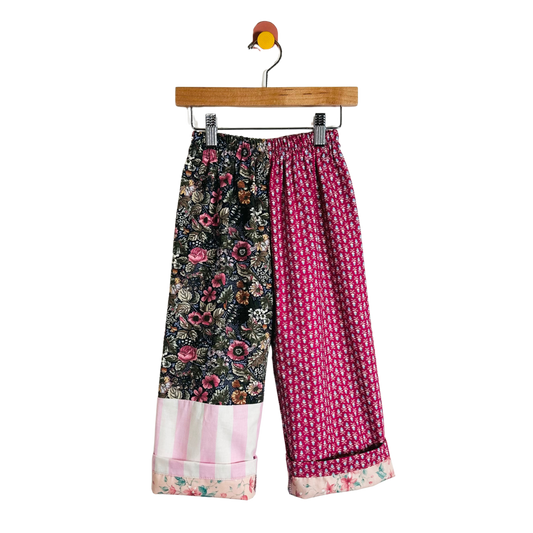 Colorful floral-patterned pants on a hanger against a white background