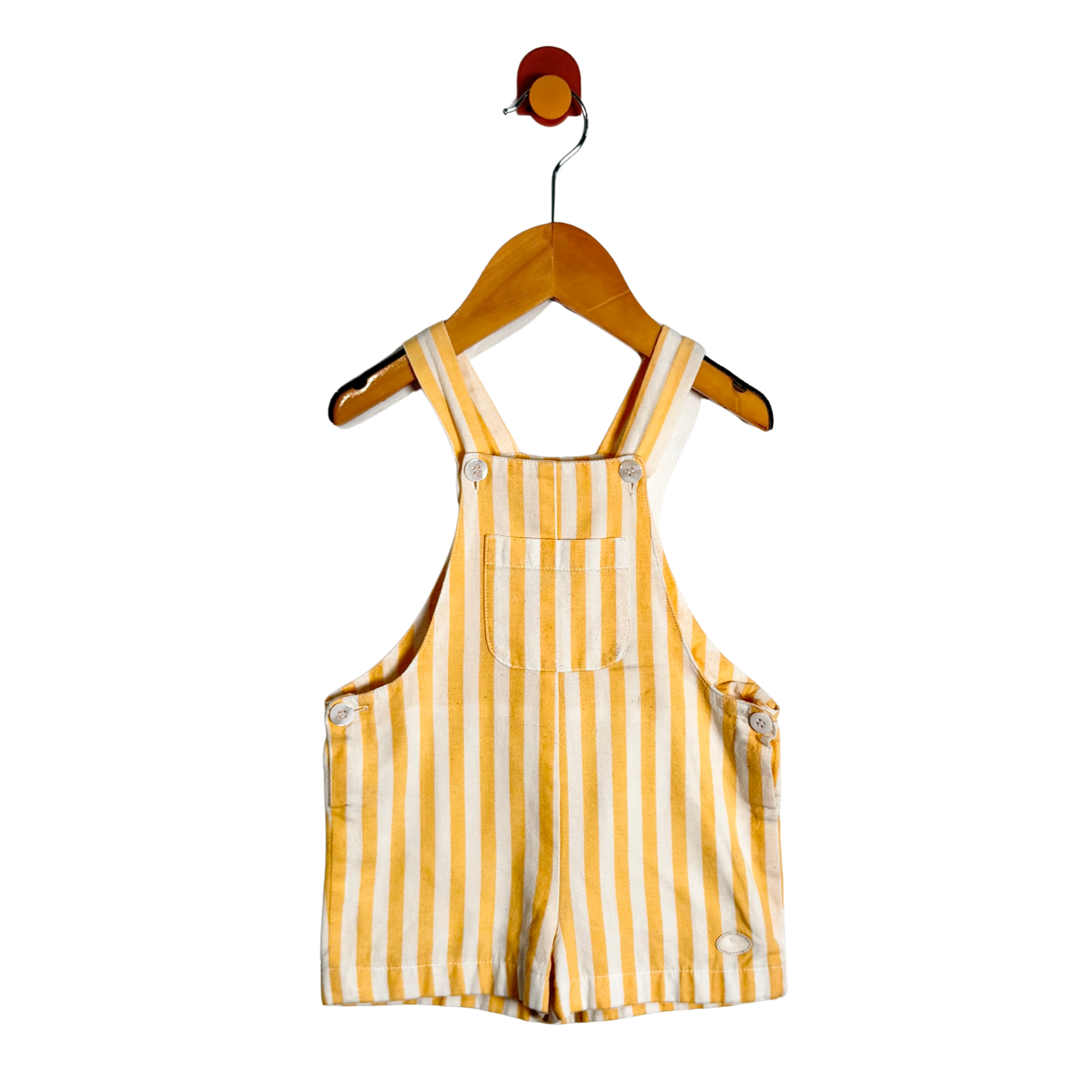 Yellow and white striped baby overalls hanging on a wooden hanger against a plain white background.