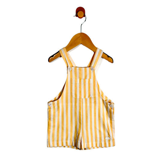 Yellow and white striped baby overalls hanging on a wooden hanger against a plain white background.