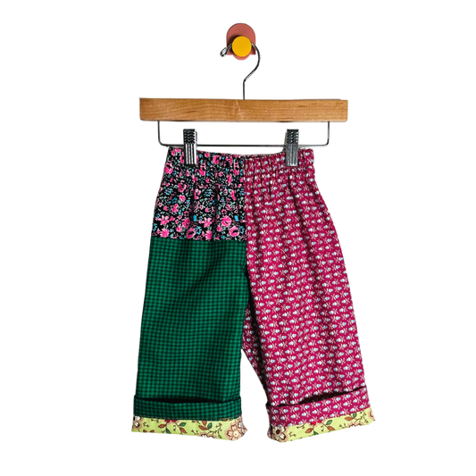 Colorful patterned pants on a hanger against a white background