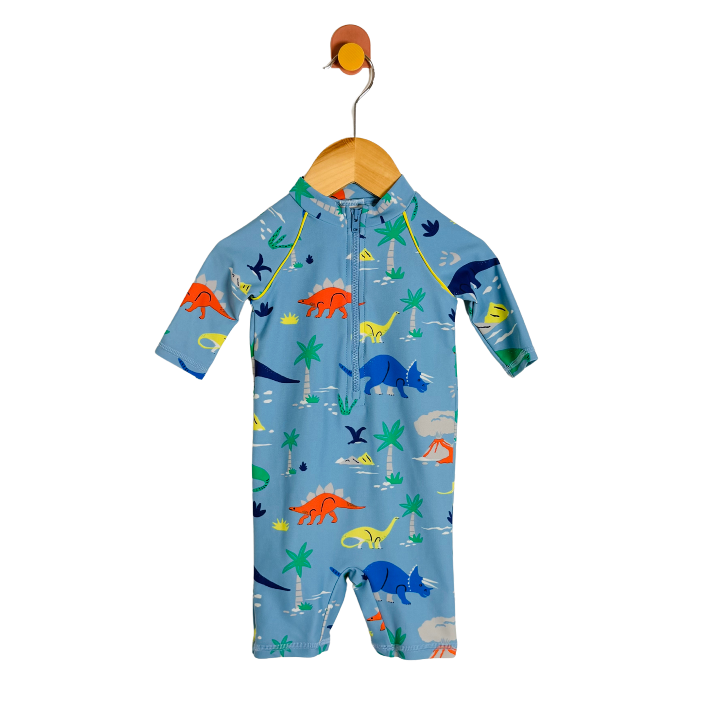 A baby long-sleeve one-piece swimsuit or sleep suit in light blue, featuring a colorful dinosaur print, hanging on a wooden hanger against a white background.