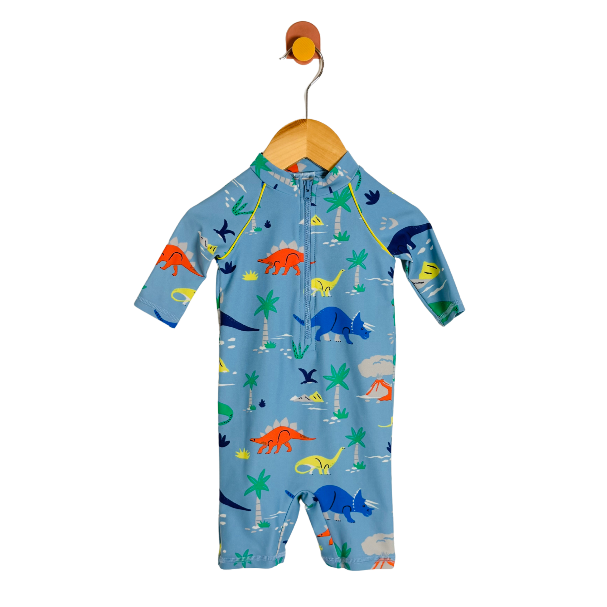 A baby long-sleeve one-piece swimsuit or sleep suit in light blue, featuring a colorful dinosaur print, hanging on a wooden hanger against a white background.