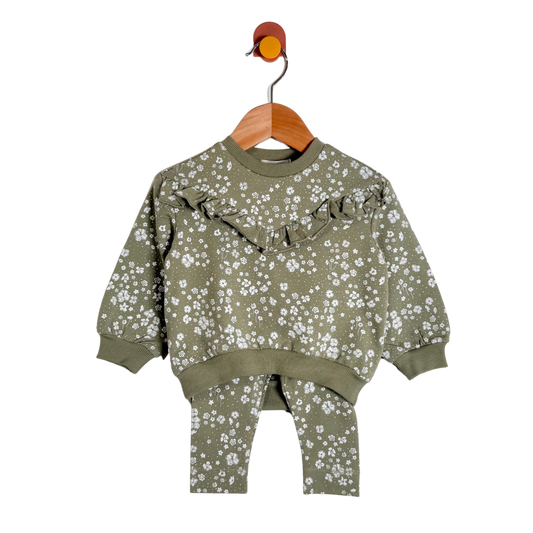 A toddler's two-piece sweatshirt and pants set in olive green with a white floral print, hanging on a wooden hanger against a plain white background.