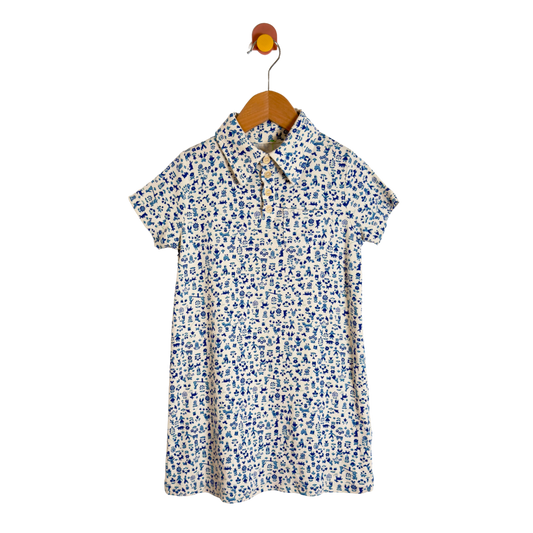A short-sleeve collared shirt dress with a blue and white floral pattern, hanging on a wooden hanger against a plain white background.