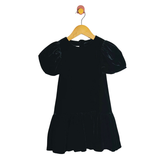 Black dress on a wooden hanger against a white background