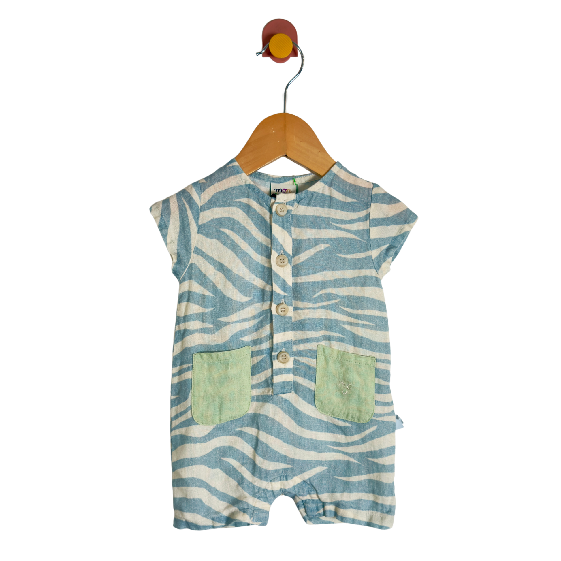 A baby short-sleeve romper with a blue and white zebra stripe pattern, featuring two light green front pockets and a button-up front, hanging on a wooden hanger against a white background.