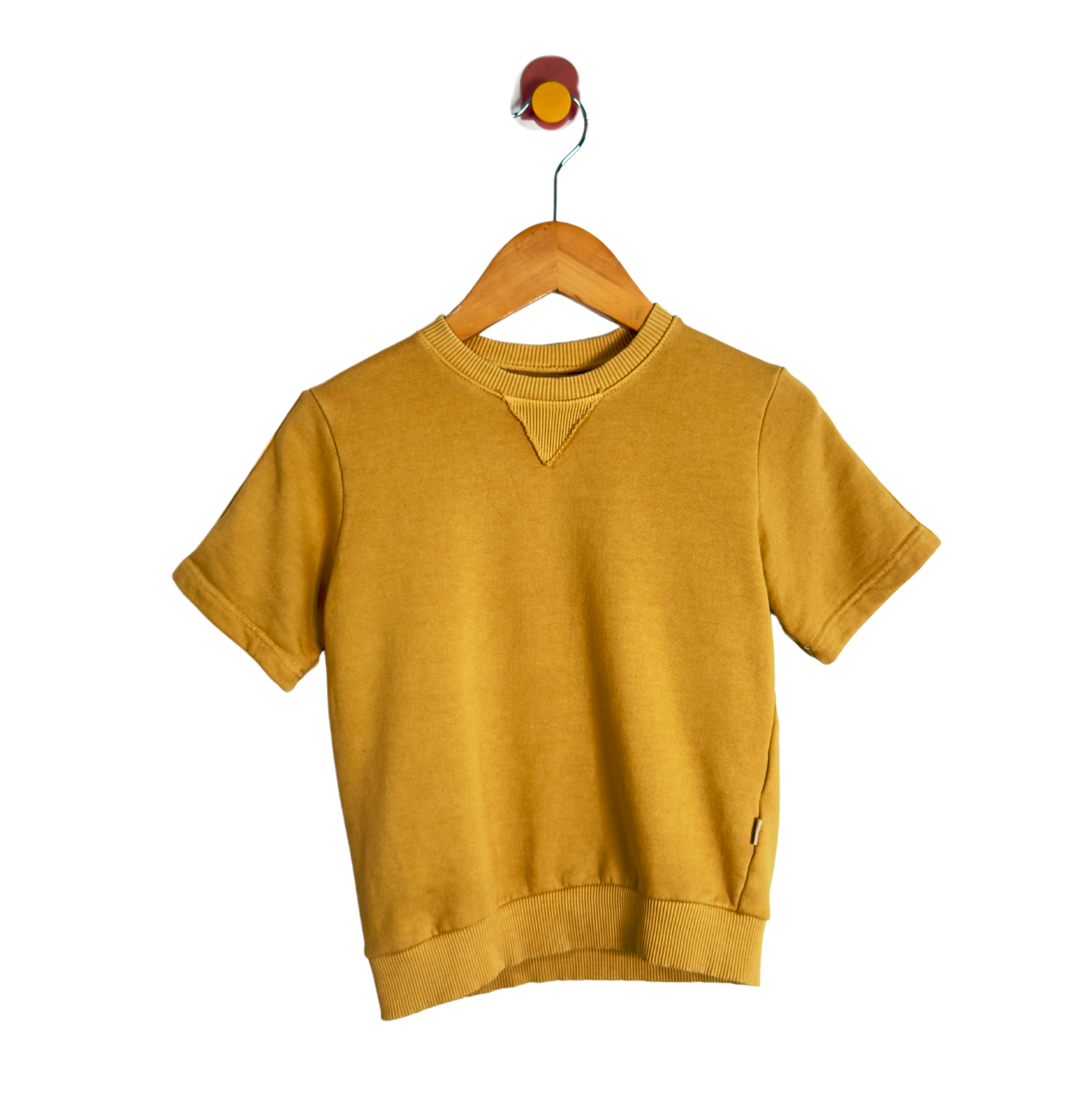 A mustard yellow short-sleeve crewneck sweatshirt hanging on a wooden hanger with a wall hook, shown against a solid white background.