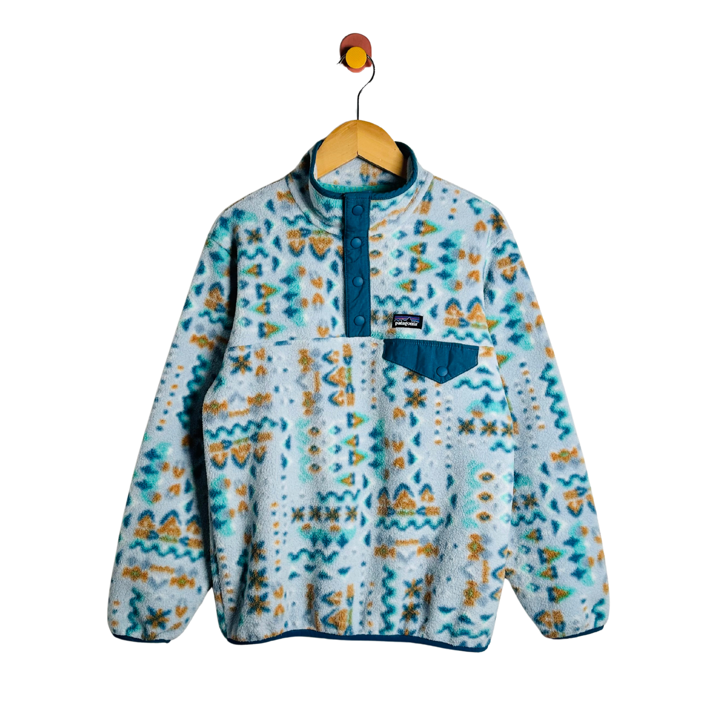 A Patagonia fleece pullover sweater with a blue and yellow geometric pattern, hanging on a wooden hanger against a white background.