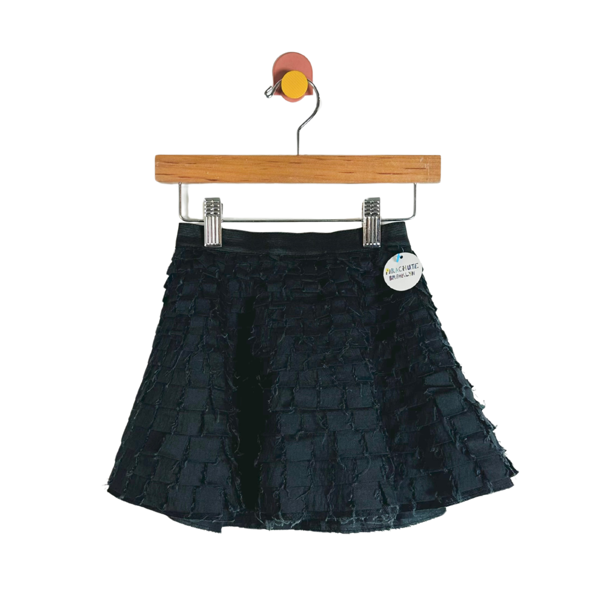 Black tiered skirt on a hanger with a visible brand tag against a white background