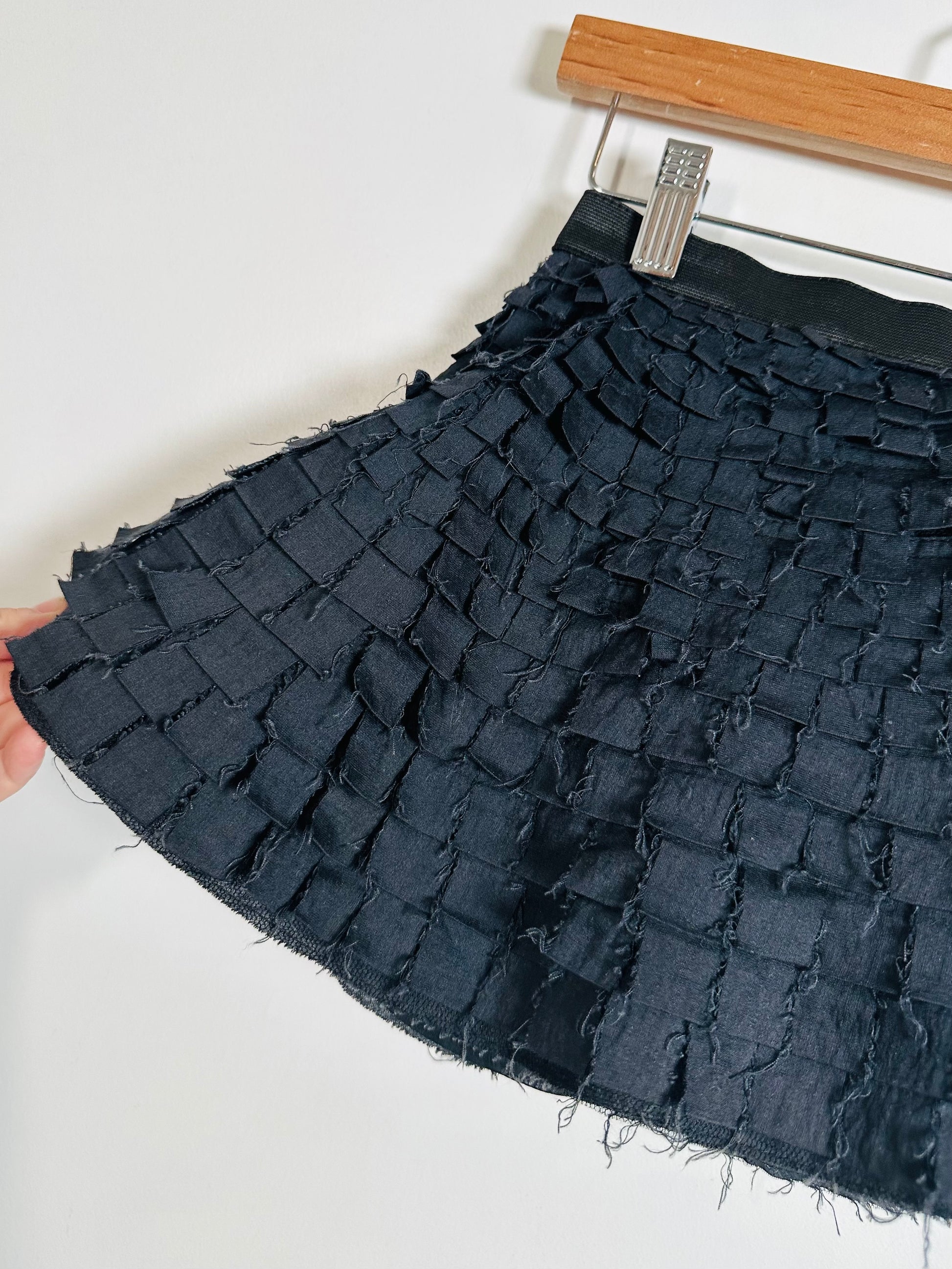 black textured fabric on a hanger against a white background