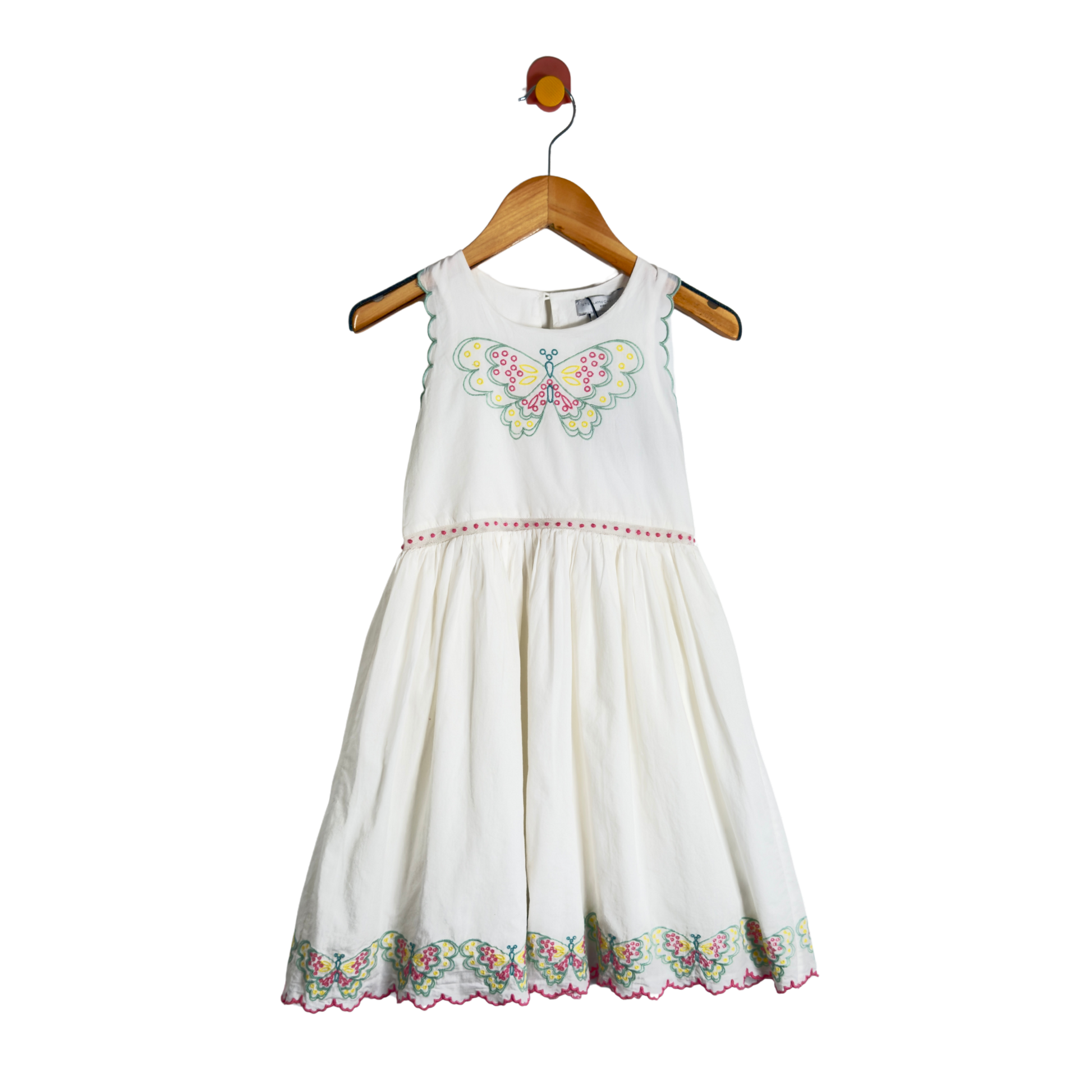 A sleeveless white children's dress with a colorful butterfly embroidery on the chest and a floral embroidered hem, hanging on a wooden hanger against a white background.
