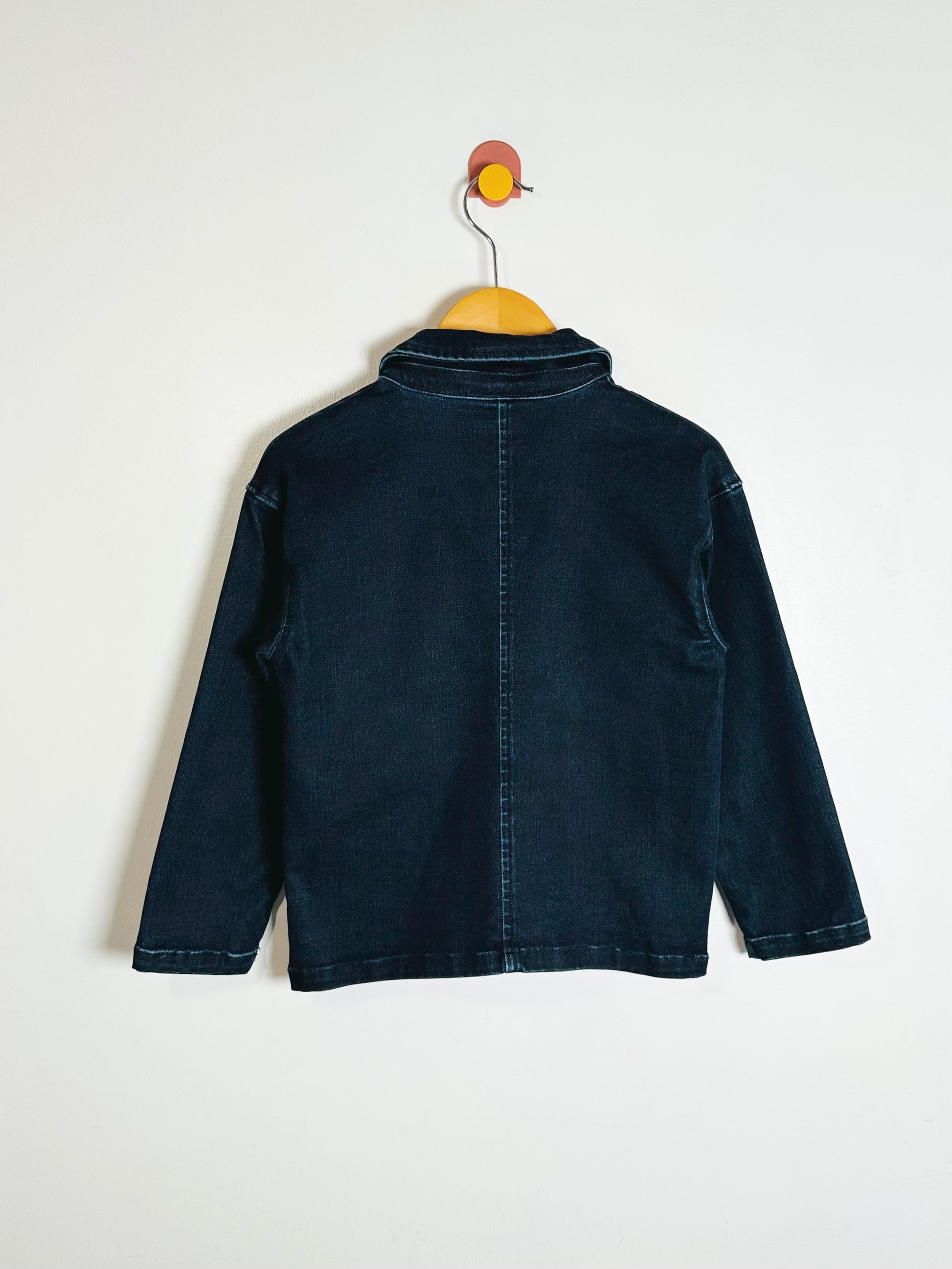Dark blue jacket on a hanger against a white background