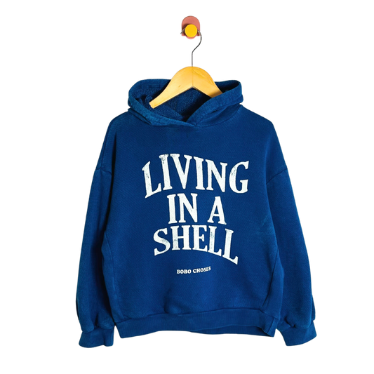 Blue hoodie with 'Living in a Shell' text on a white background