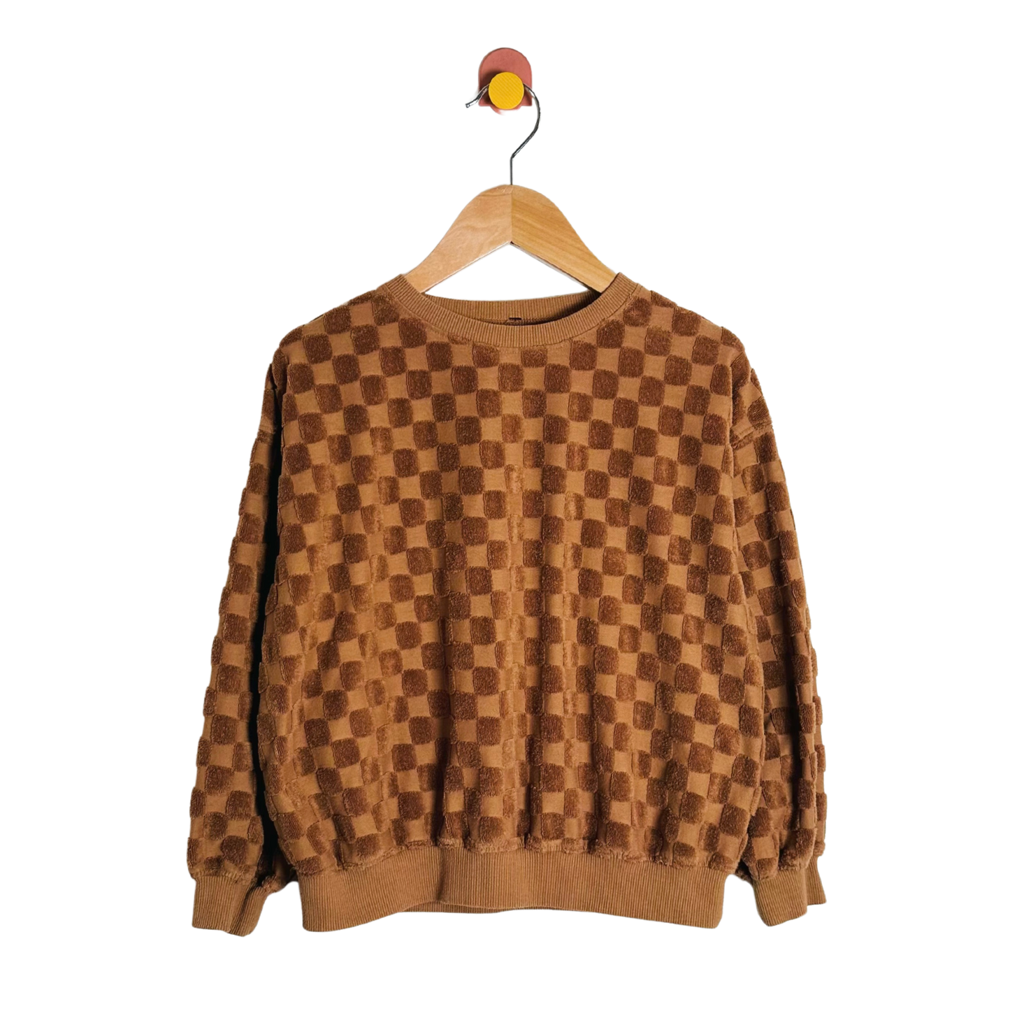 Brown checkered sweater on a wooden hanger against a white background