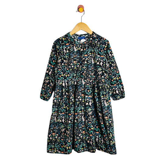 Floral patterned dress on a hanger against a white background