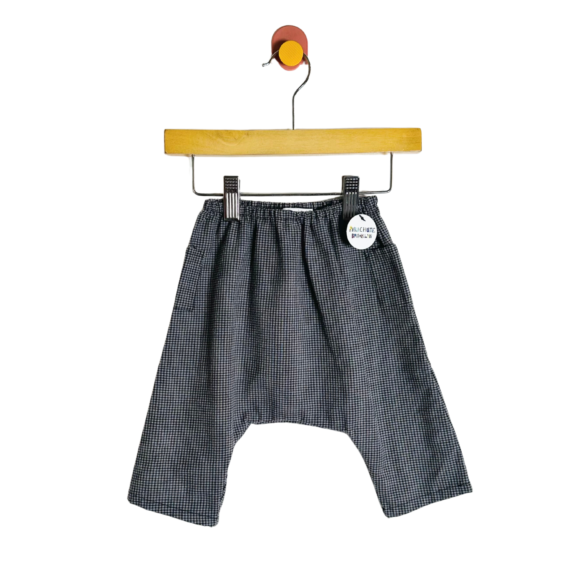 Black checkered shorts on a hanger with a white background