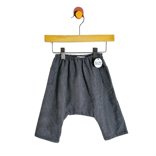Black checkered shorts on a hanger with a white background