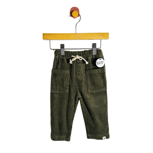 Green corduroy pants on a hanger with a white background