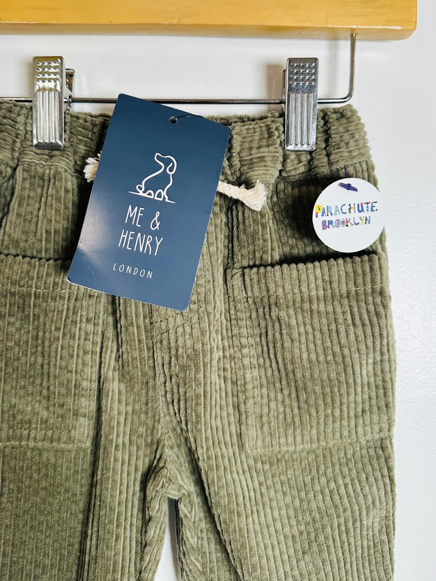 Green corduroy pants with a 'Me & Henry London' tag on a white background.