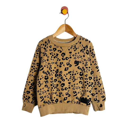 Beige sweater with black leopard print on a wooden hanger against a white background