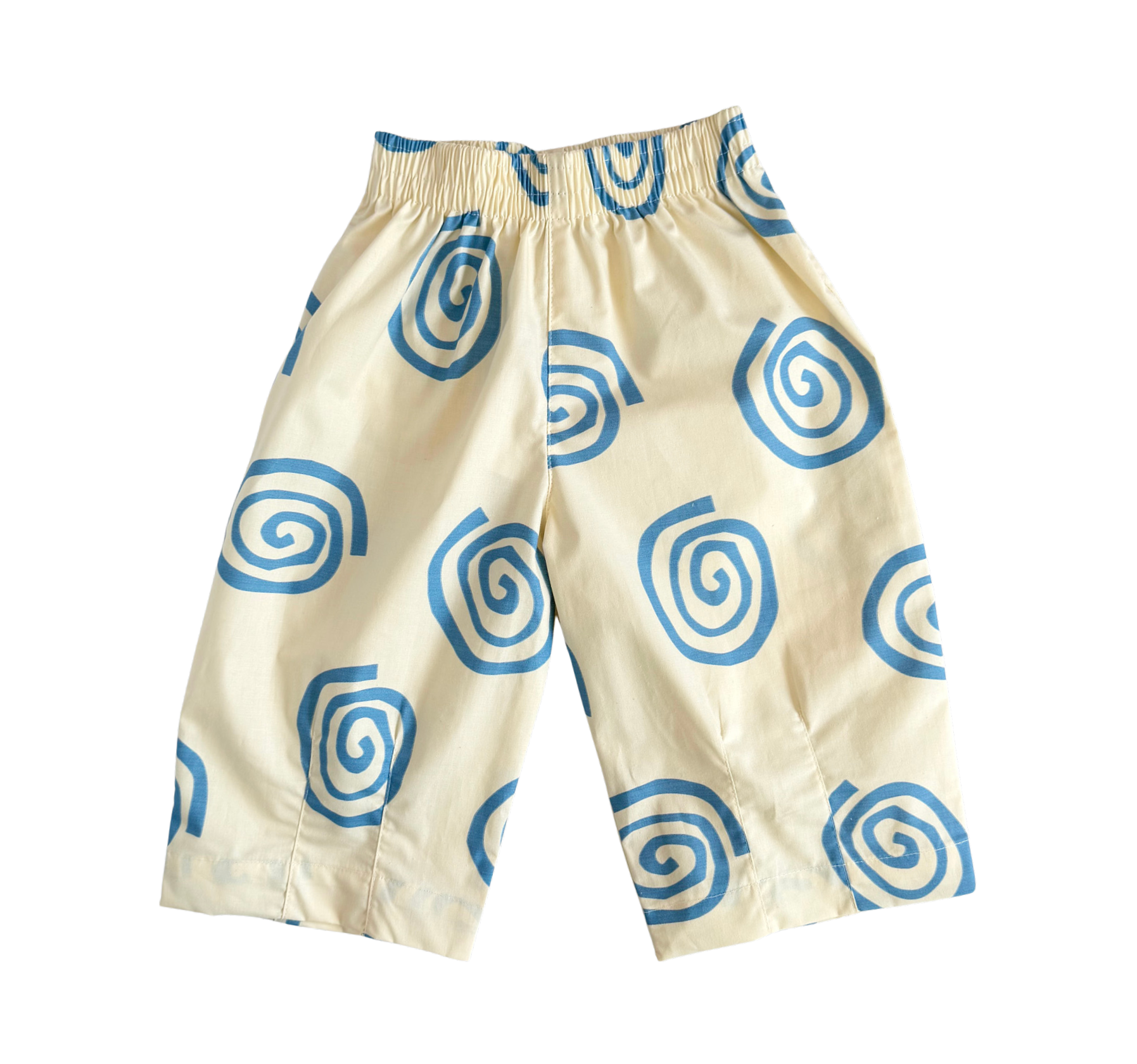 A pair of cream-colored pants with a blue spiral pattern, featuring an elastic waistband, shown against a plain white background.