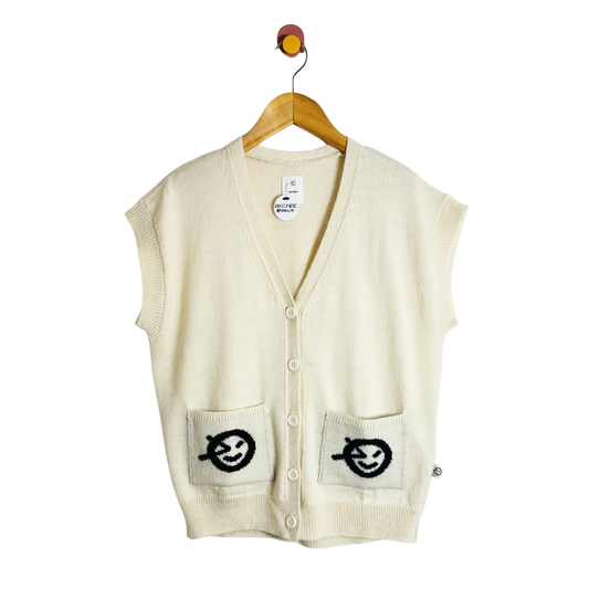 Beige cardigan vest with designs on pockets, hanging on a wooden hanger against a white background.