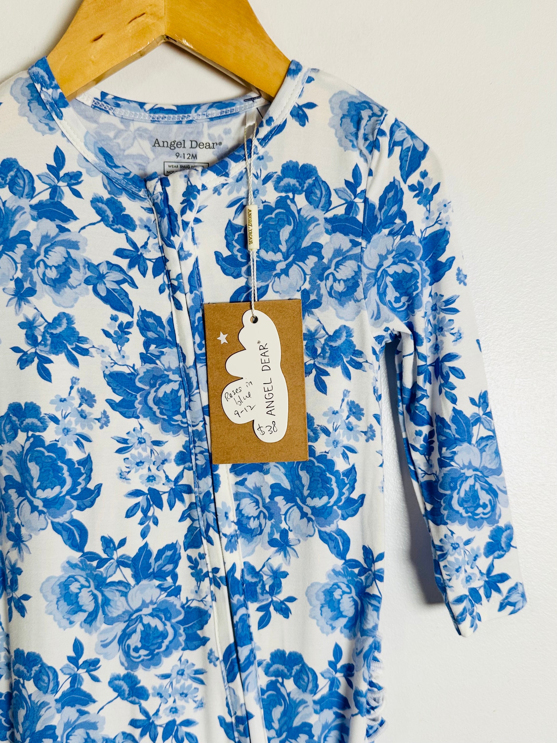Blue floral onesie on a hanger with a visible brand tag.
