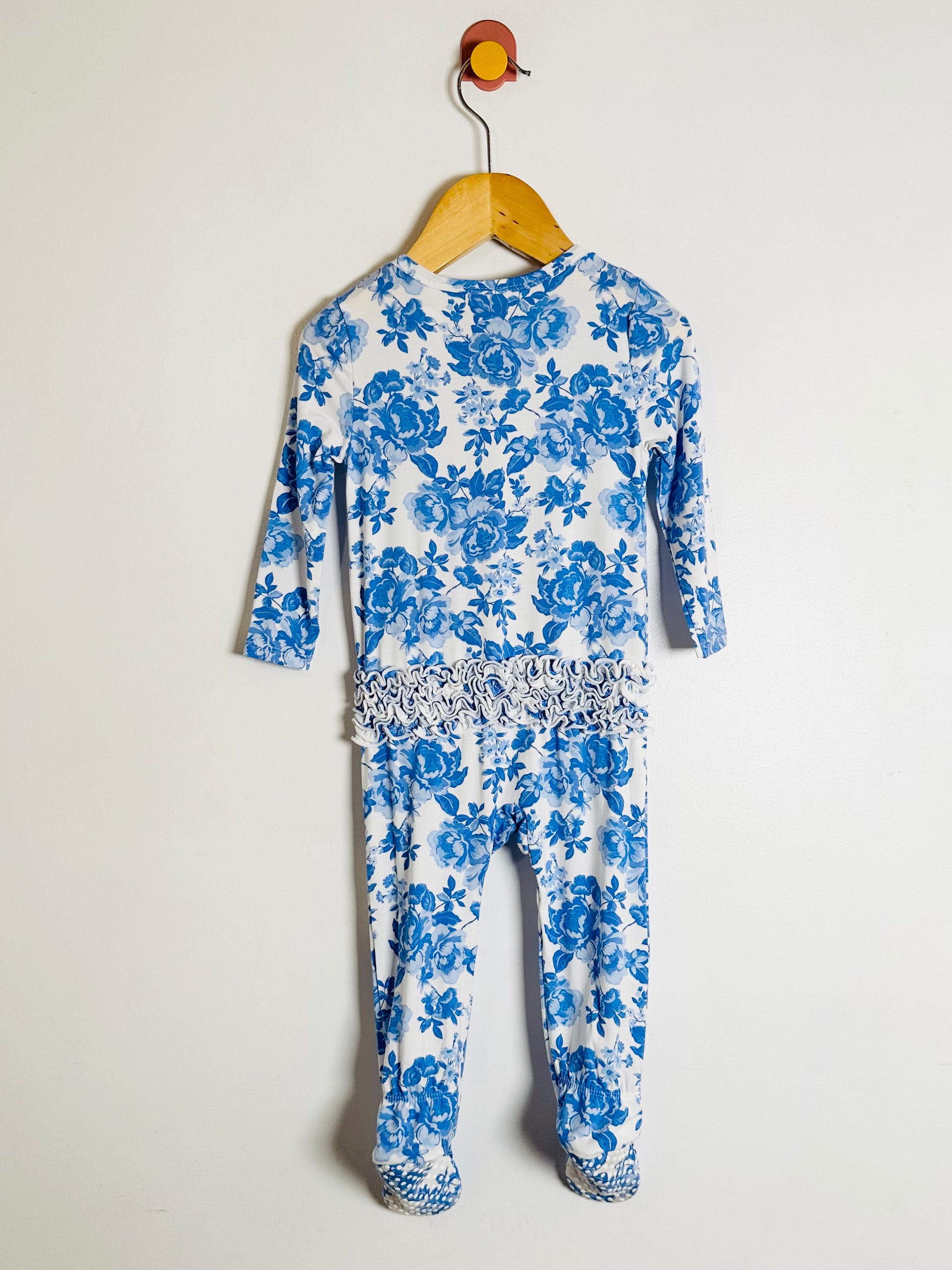 Blue floral baby onesie on a hanger against a white background