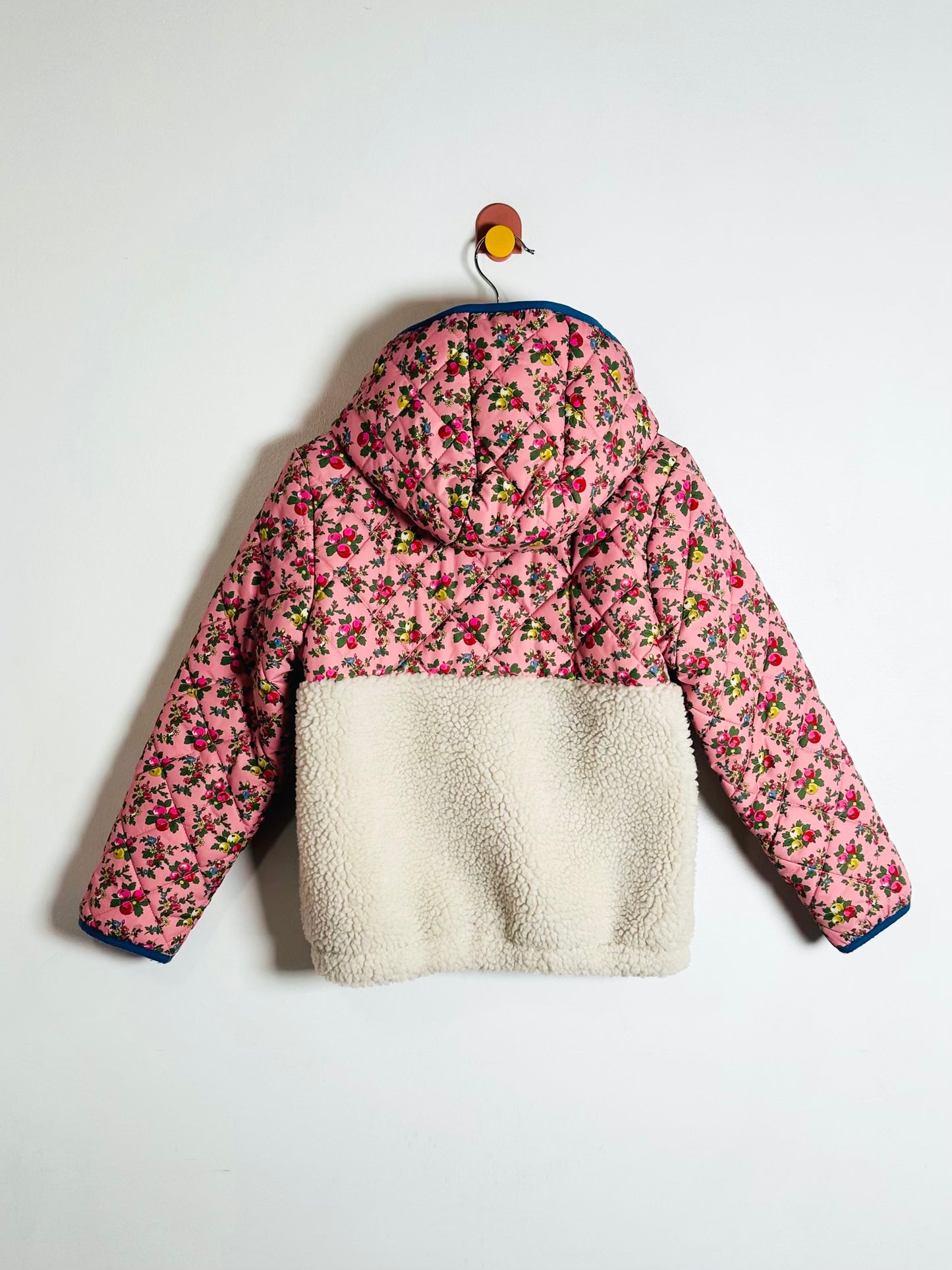 Floral patterned jacket with white fleece lining on a white background