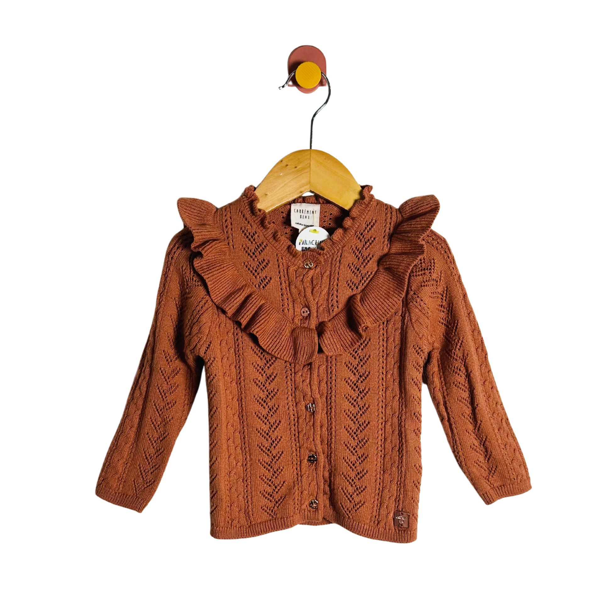 Brown knitted jacket on a wooden hanger with a white background
