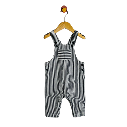 Black and white striped overalls on a hanger against a white background