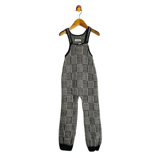 Black and white checkered overalls on a hanger against a white background