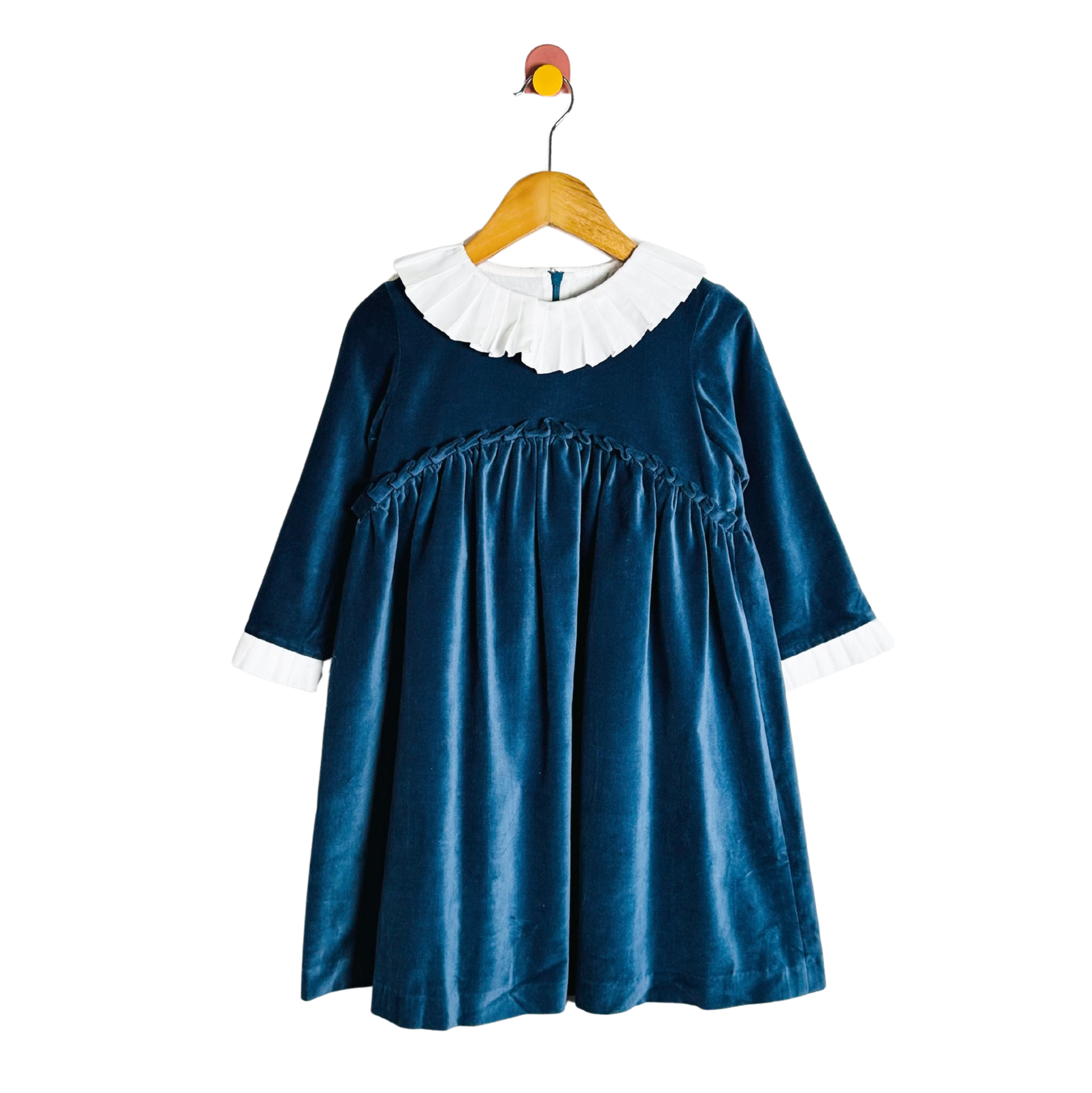 Blue dress with white collar on a wooden hanger against a white background