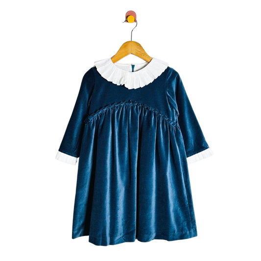 Blue dress with white collar on a wooden hanger against a white background