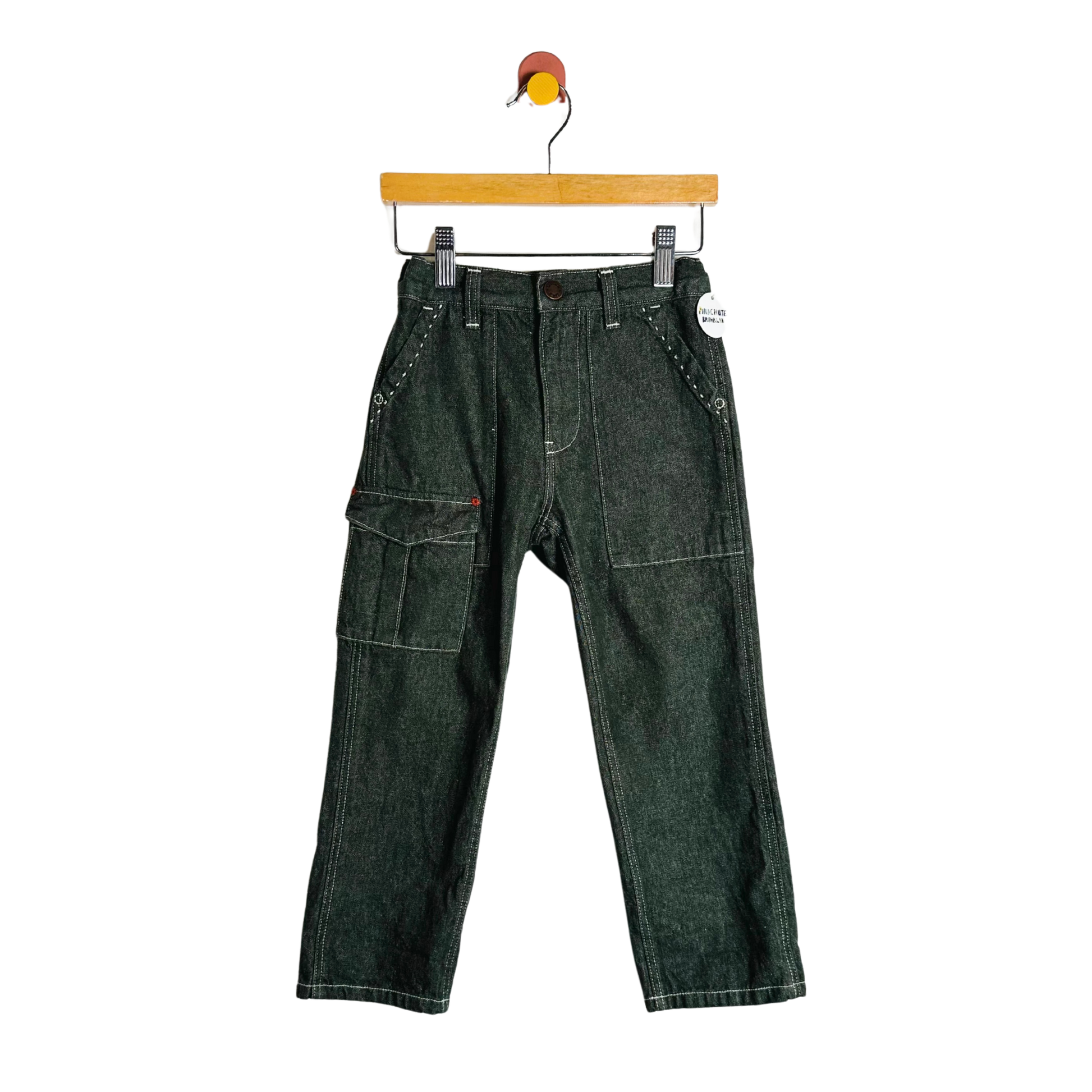 Green denim pants on a hanger against a white background