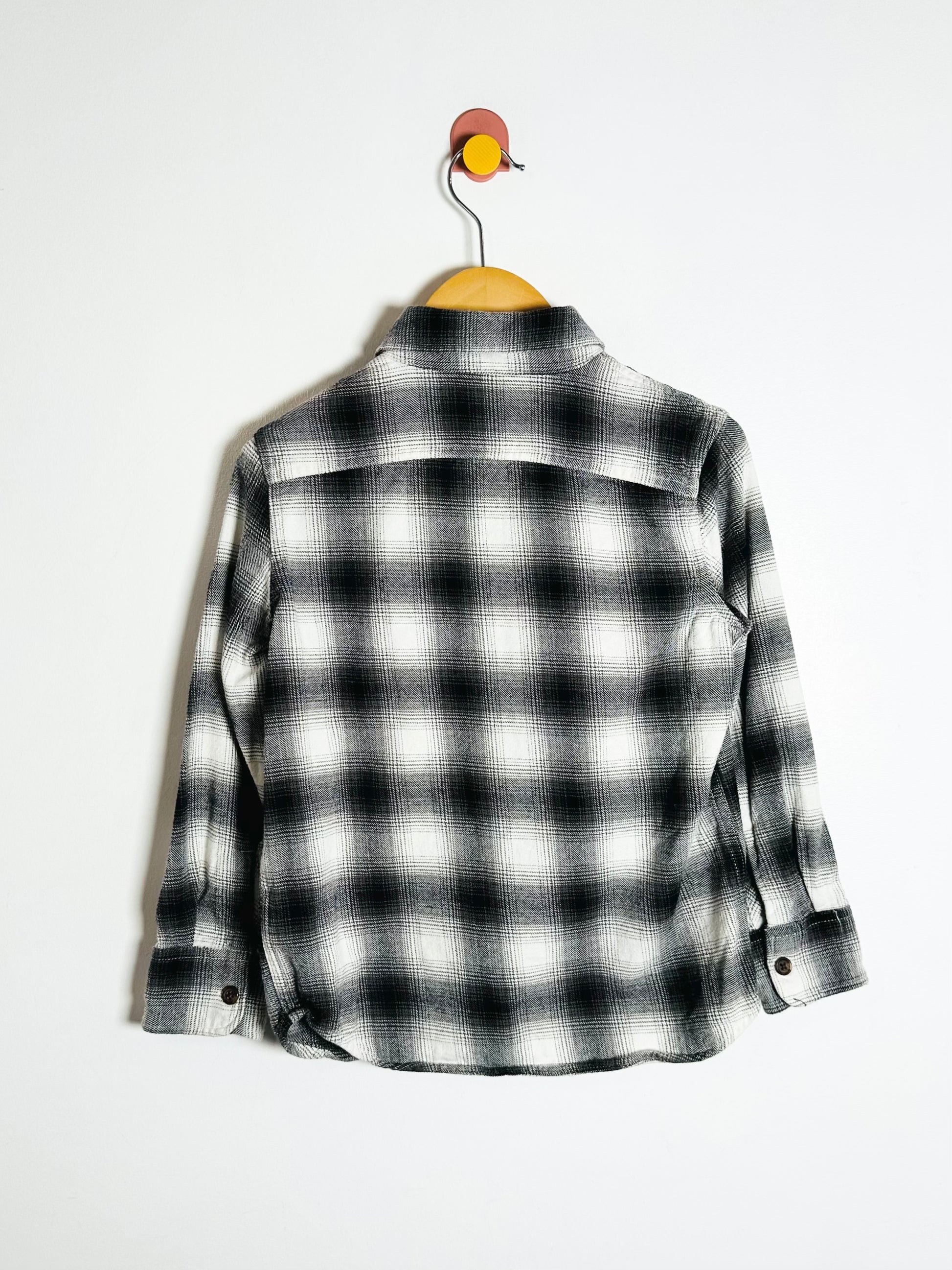 Black and white checkered shirt on a hanger against a white background