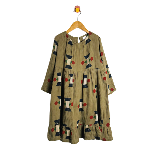 Green dress with geometric pattern on a hanger against a white background