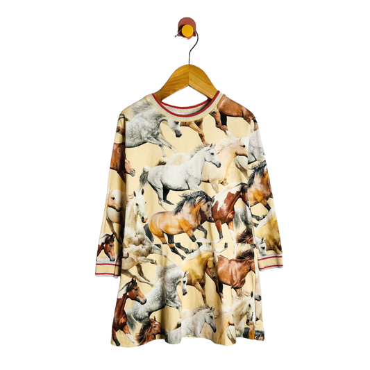 Dress with horse print on a hanger against a white background