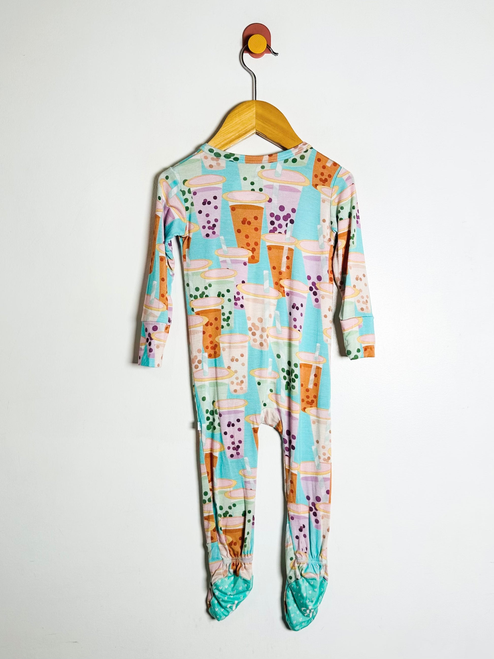 Colorful baby onesie with a pattern on a hanger against a white background