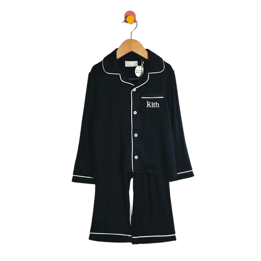 Black pajama set with white piping on a hanger against a white background