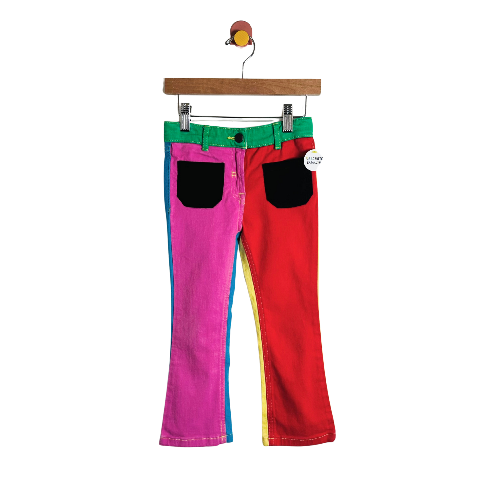 Colorful pants with a green belt on a hanger against a white background