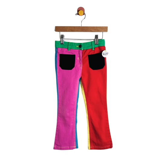 Colorful pants with a green belt on a hanger against a white background