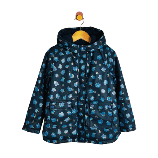 A hooded children's jacket in navy blue with a repeating light blue and white animal print, hanging on a wooden hanger against a plain white background.