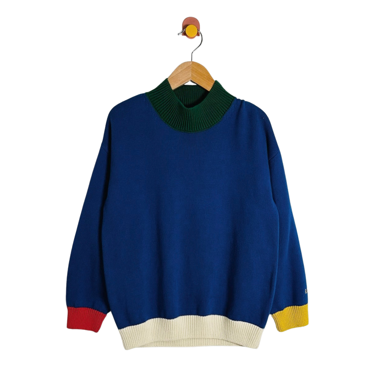 A blue knit sweater with a dark green mock neck, cream ribbed hem and cuffs, and red and yellow color-blocked accents at the cuffs, hanging on a wooden hanger against a white background.