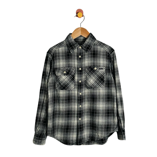 A long-sleeve plaid button-up shirt in black and off-white, hanging on a wooden hanger with a small bird-shaped hook against a plain white background.