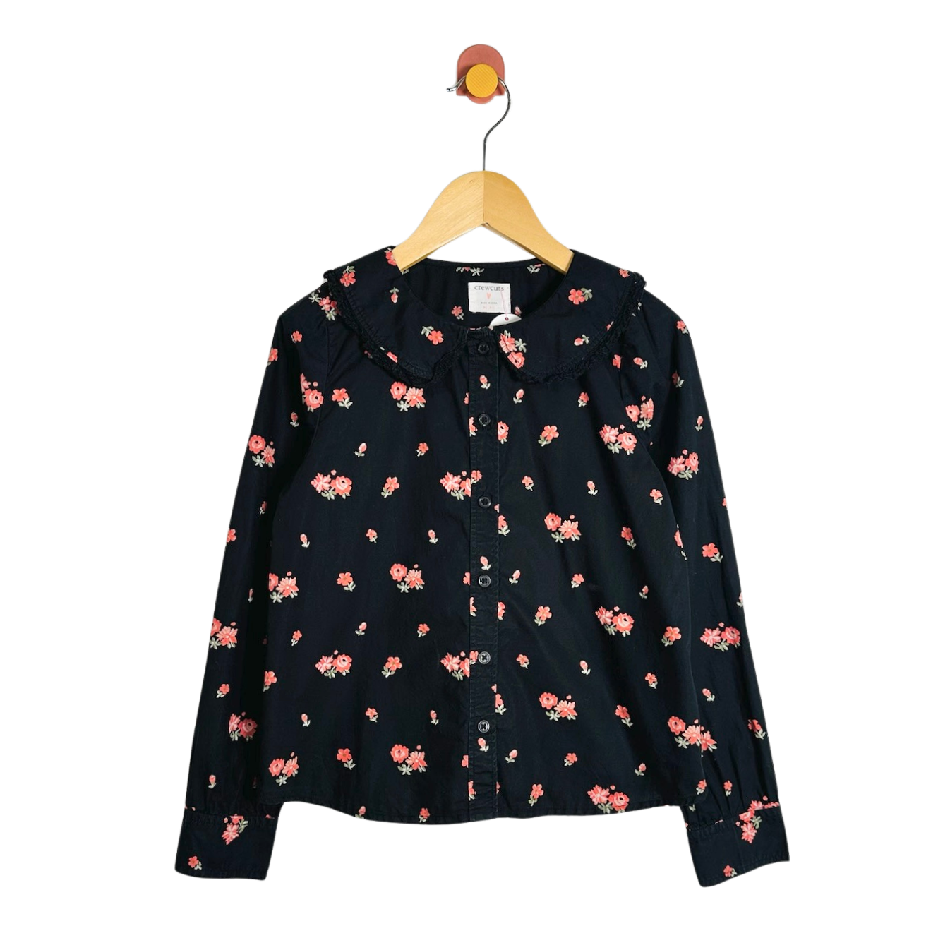A black long-sleeve button-up blouse with a small pink and orange floral print, hanging on a wooden hanger against a white background.
